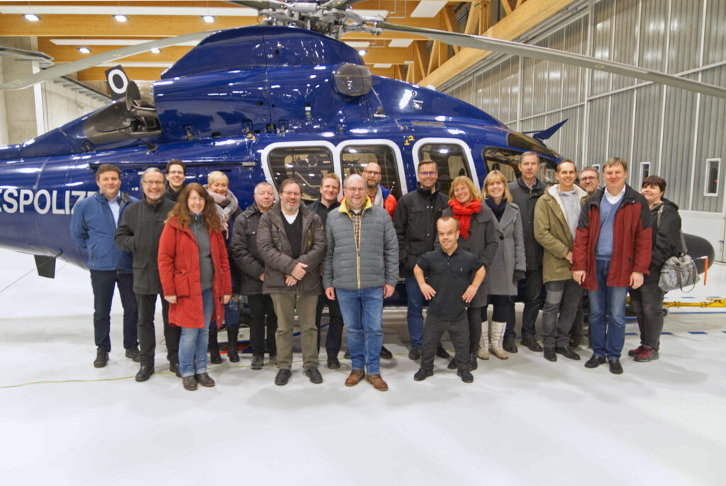 Die Besucher der BG Landesbehörden beim Gruppenfoto vor einem der Airbus-Hubschraubern - dem Arbeitsgerät von Lisa und ihren Kollegen.